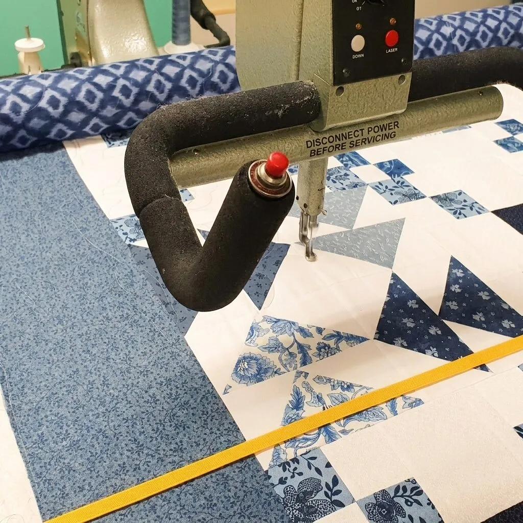 A patchwork top being finished on a long-arm quilting machine