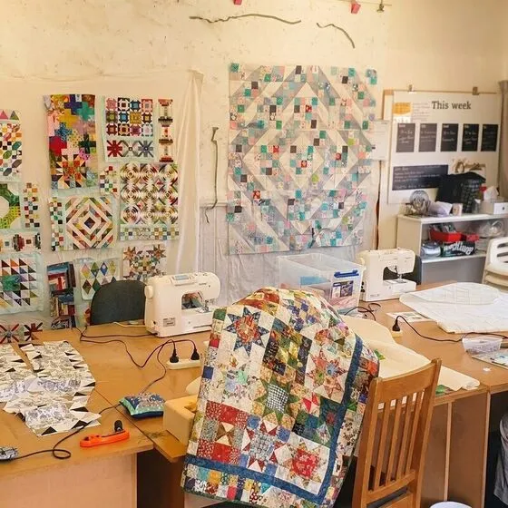 A finished patchwork quilt draped over an armchair